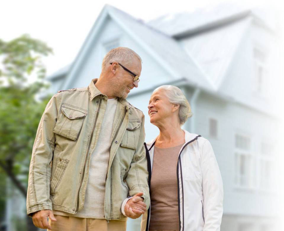 Senior couple holding hands infront of home